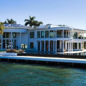Stunning modern mansion with palm trees by Florida waterfront, perfect for luxury living.
