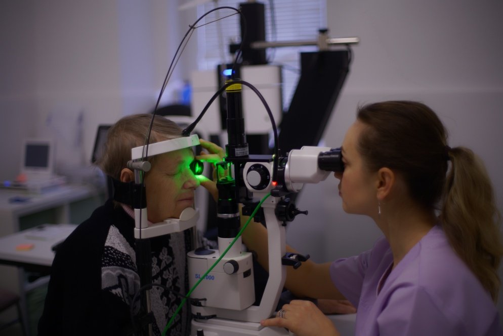 An ophthalmologist inspecting a patient's eyes